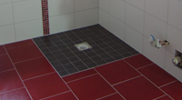 Bad mit bodengleicher Dusche in drei Farbtönen